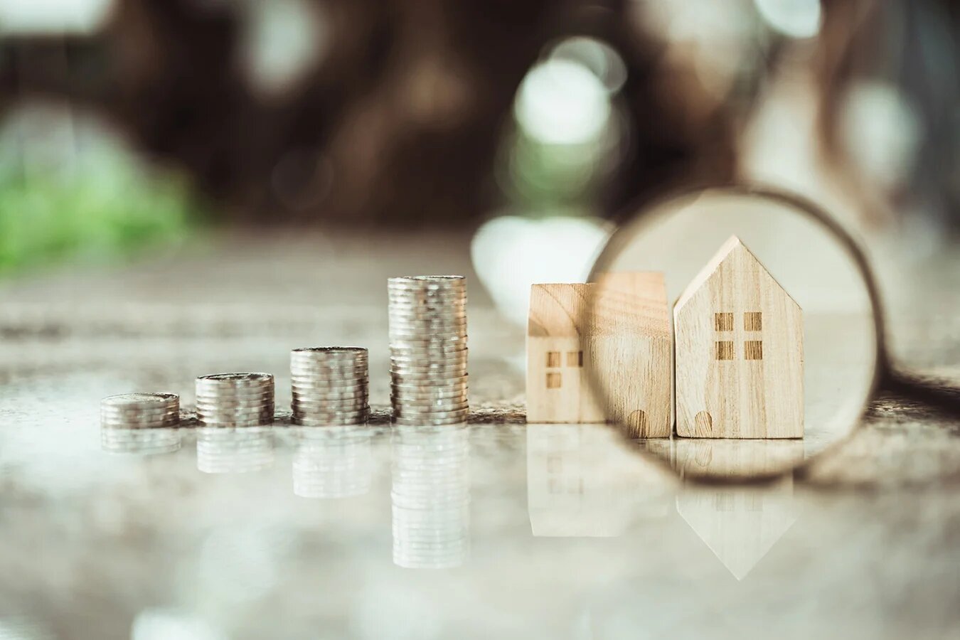 4 tas de pièces + petites maisons en bois avec loupe sur l'une d'entre elle